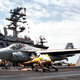 Deck handlers salute as the last Grumman A-6E Intruder launches from the flight deck of the aircraft carrier USS George Washington (CVN 73) on July 22, 1996 after the Intruder’s final deployment.